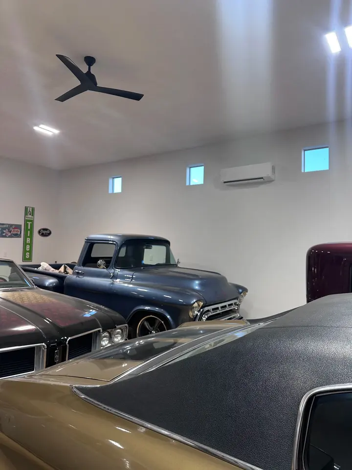 Mini split indoor head in a garage full of classic cars