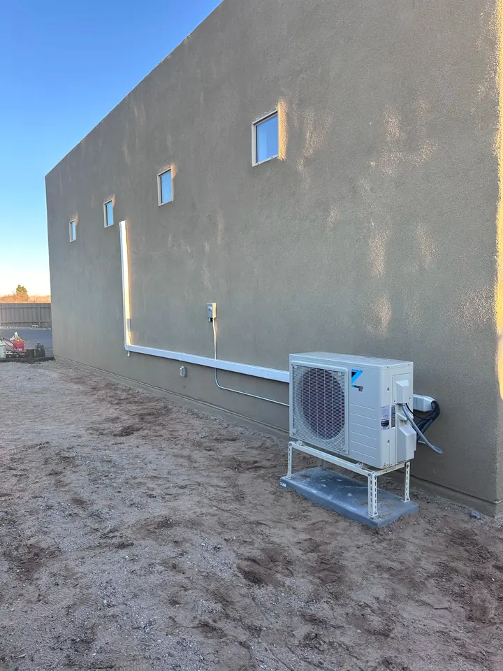 Mini split outdoor unit against a stucco wall
