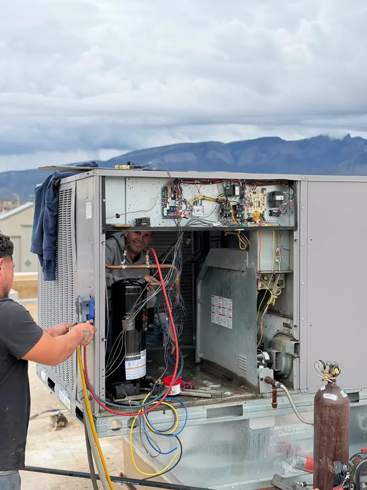 Technician servicing an open rooftop unit