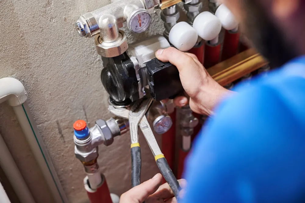 Technician connecting gauges and valves on refrigerant lines